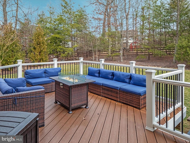 wooden deck featuring fence and an outdoor living space with a fire pit