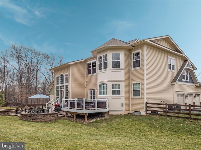 rear view of house with a patio area, fence, a lawn, and a wooden deck