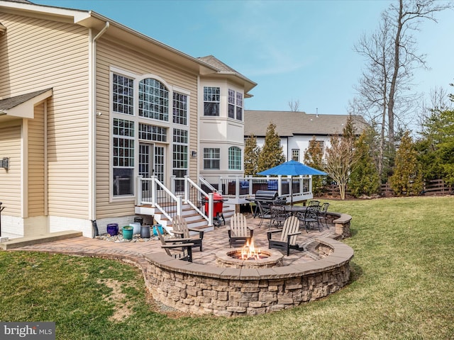 rear view of house with an outdoor fire pit, a patio area, and a yard