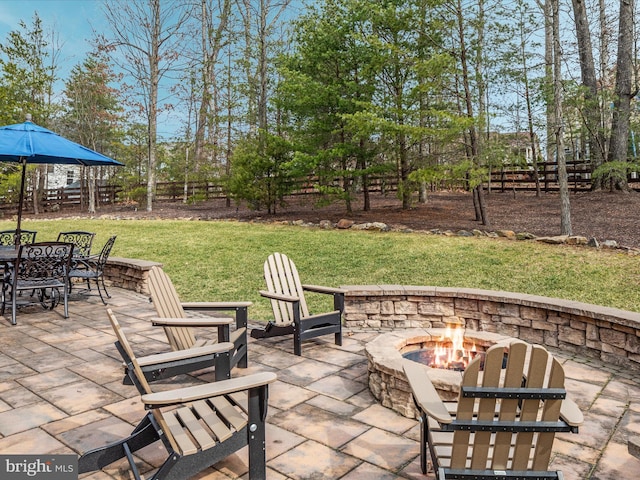 view of patio featuring an outdoor fire pit, outdoor dining space, and fence