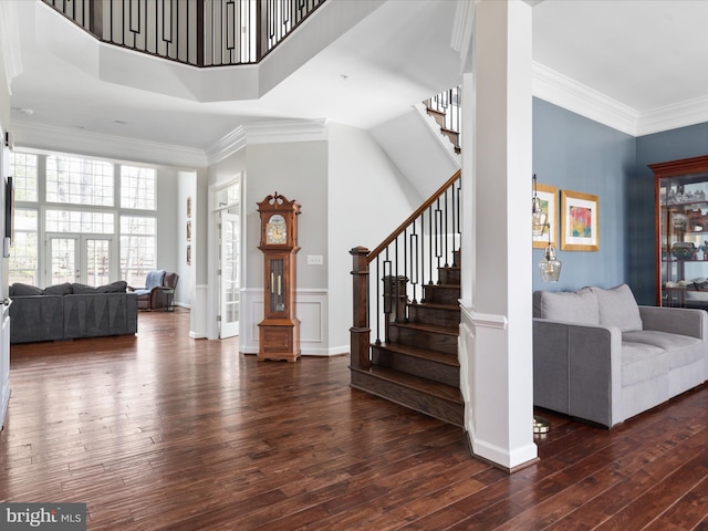 entrance foyer with hardwood / wood-style flooring, stairs, and crown molding