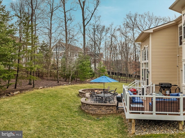 view of yard featuring a fire pit, a deck, and fence