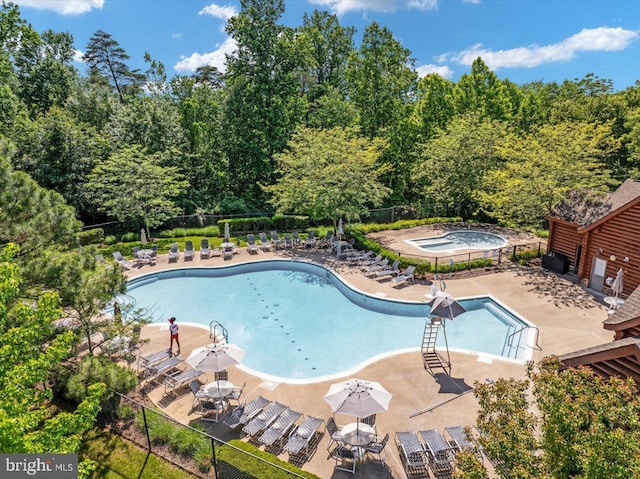 pool featuring a patio area, fence, and a hot tub