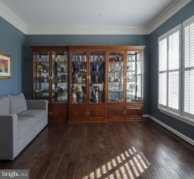 unfurnished dining area featuring baseboards, ornamental molding, and dark wood-type flooring