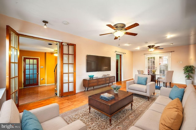 living area featuring ceiling fan, french doors, wood finished floors, and baseboards