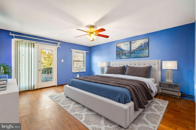 bedroom featuring access to exterior, a ceiling fan, and wood finished floors