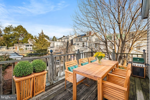 wooden deck with grilling area, a residential view, and outdoor dining area