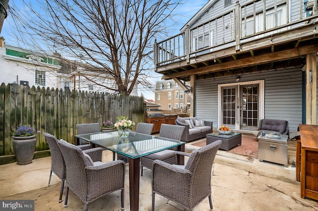 view of patio with french doors, fence, outdoor dining area, and an outdoor hangout area