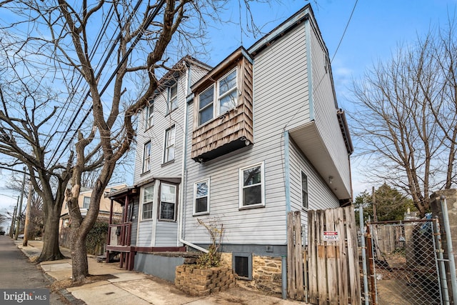 view of side of home featuring fence