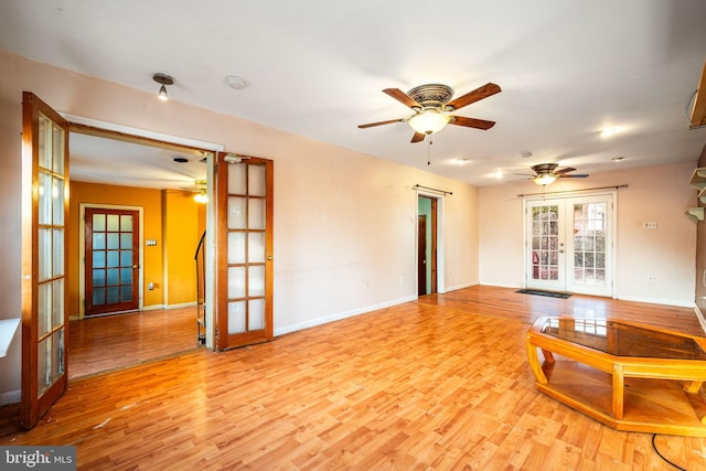 unfurnished living room with french doors, wood finished floors, and baseboards