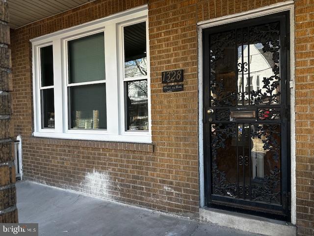 entrance to property featuring brick siding