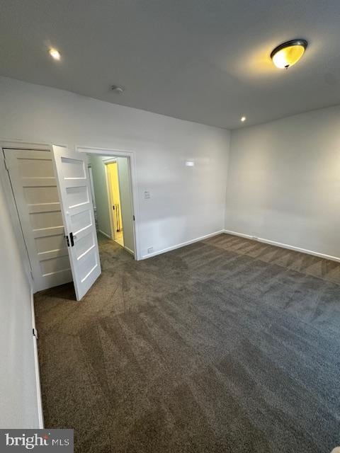 unfurnished bedroom featuring dark colored carpet, baseboards, and recessed lighting