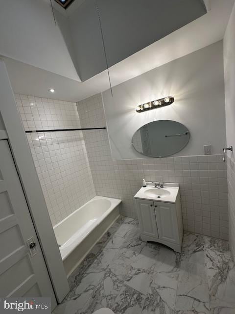 bathroom featuring marble finish floor, vanity, and tile walls