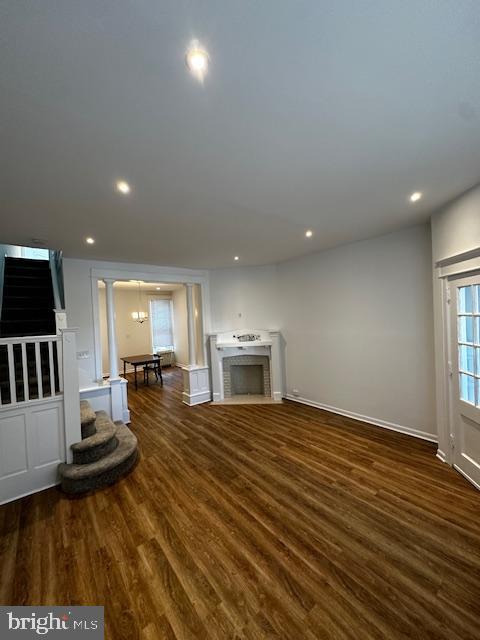 unfurnished living room with dark wood-style floors, a fireplace, and recessed lighting