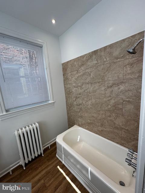 full bathroom featuring radiator, baseboards, and wood finished floors