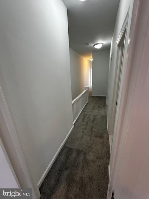 hallway with carpet flooring and baseboards