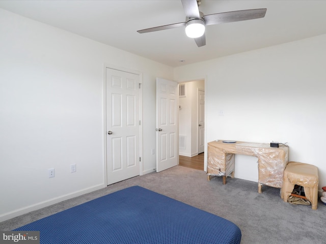 carpeted bedroom with visible vents, a ceiling fan, and baseboards