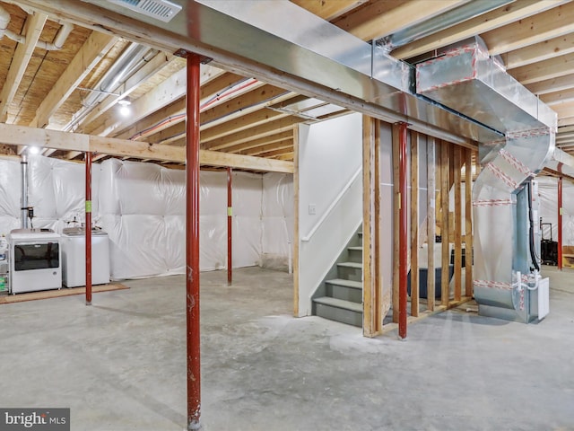 unfinished basement featuring heating unit, washing machine and dryer, visible vents, and stairway