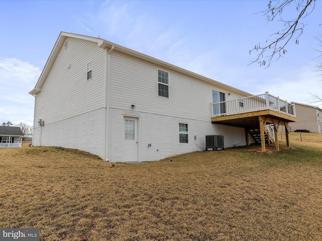 back of house with brick siding, a lawn, central AC, a wooden deck, and stairs