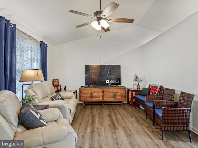 living area with lofted ceiling, a ceiling fan, and wood finished floors