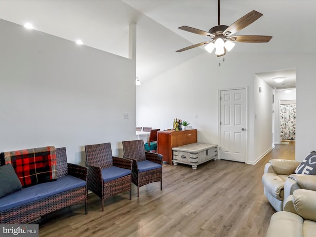 living room featuring ceiling fan, high vaulted ceiling, and light wood finished floors