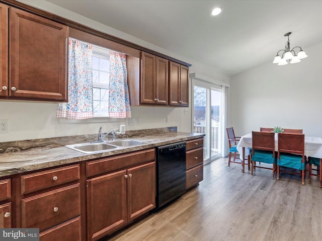 kitchen featuring lofted ceiling, a sink, hanging light fixtures, dishwasher, and light wood finished floors