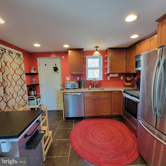 kitchen with stainless steel appliances, recessed lighting, brown cabinetry, and a sink