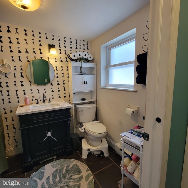 bathroom featuring tile patterned flooring, baseboards, vanity, and toilet