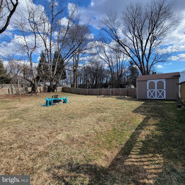 view of yard with a fenced backyard, a storage unit, and an outdoor structure