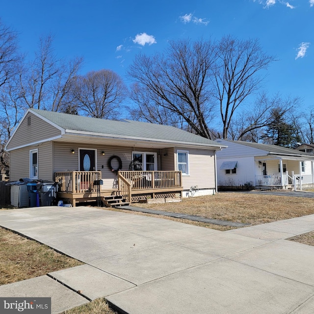 single story home with driveway, covered porch, and a shingled roof