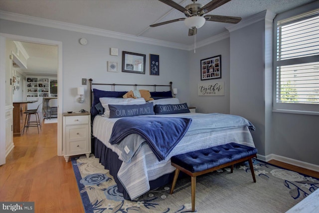 bedroom with light wood-style flooring, ceiling fan, baseboards, and ornamental molding