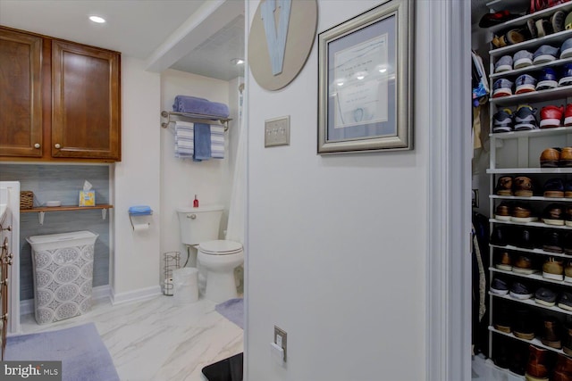 bathroom featuring recessed lighting, marble finish floor, toilet, and baseboards