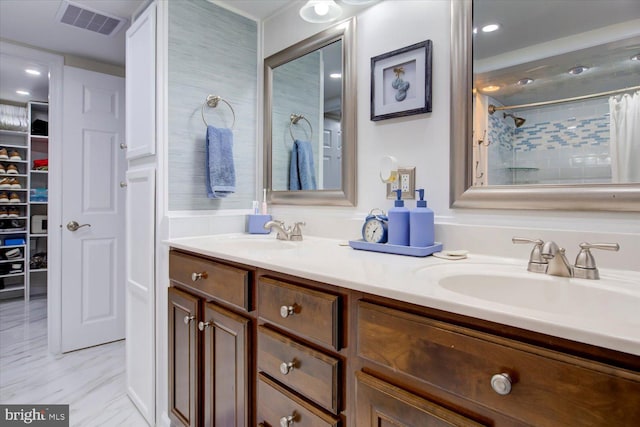 full bath featuring a sink, visible vents, marble finish floor, and double vanity