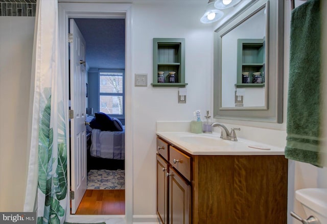 bathroom with vanity, ensuite bathroom, and wood finished floors