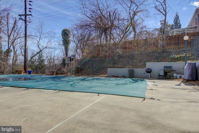 view of swimming pool with a patio area, grilling area, a fenced in pool, and fence