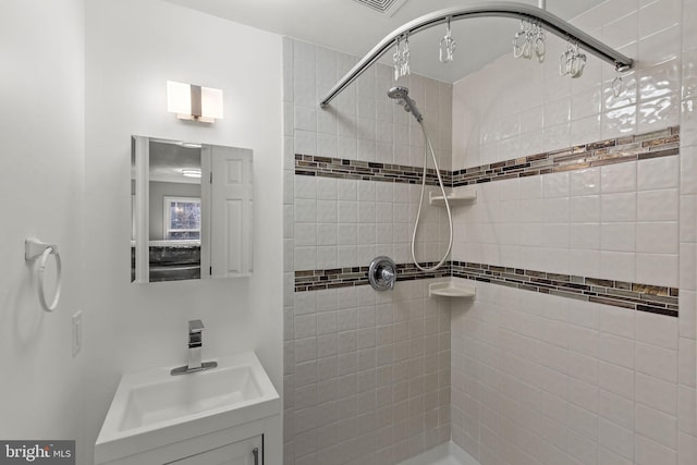 full bath featuring vanity and a tile shower