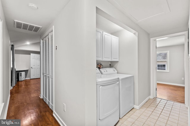 laundry area featuring visible vents, baseboards, light tile patterned floors, cabinet space, and separate washer and dryer