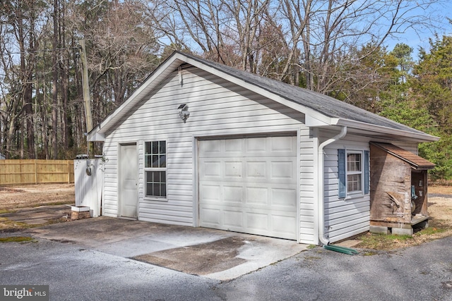 detached garage featuring fence