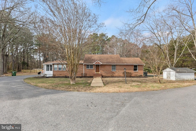 ranch-style house with brick siding, driveway, and a front yard