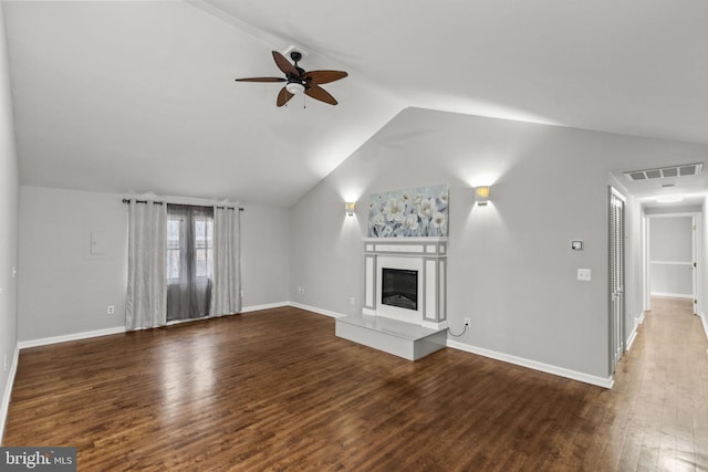 unfurnished living room with a tiled fireplace, visible vents, lofted ceiling, and wood finished floors