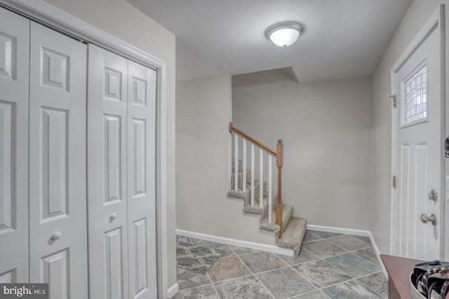 entrance foyer with stairway and baseboards