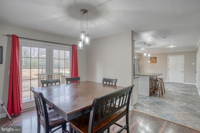 dining room with ornamental molding, french doors, wood finished floors, and baseboards