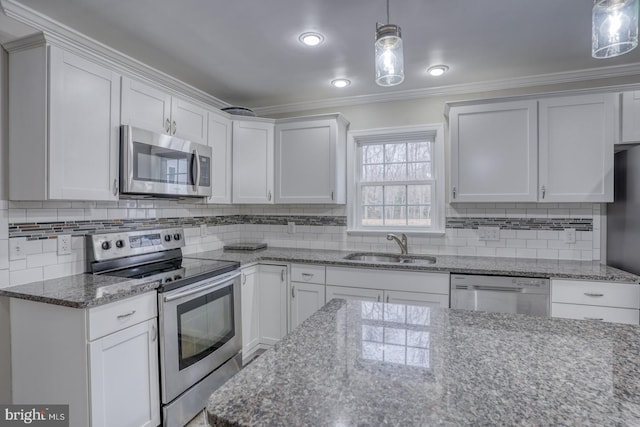 kitchen featuring tasteful backsplash, appliances with stainless steel finishes, ornamental molding, white cabinetry, and a sink