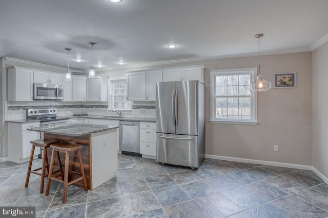 kitchen with tasteful backsplash, a kitchen island, appliances with stainless steel finishes, and a sink