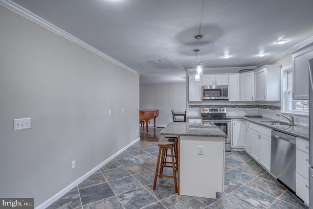 kitchen with a center island, decorative backsplash, appliances with stainless steel finishes, ornamental molding, and a sink