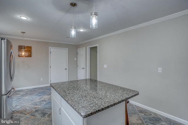 kitchen featuring a center island, baseboards, ornamental molding, and freestanding refrigerator