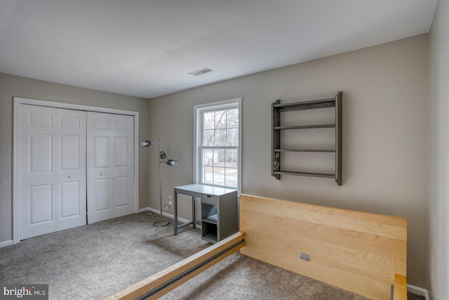 unfurnished bedroom with carpet floors, a closet, visible vents, and baseboards