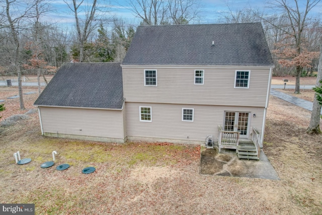 back of property with french doors and roof with shingles