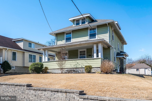 american foursquare style home featuring a porch