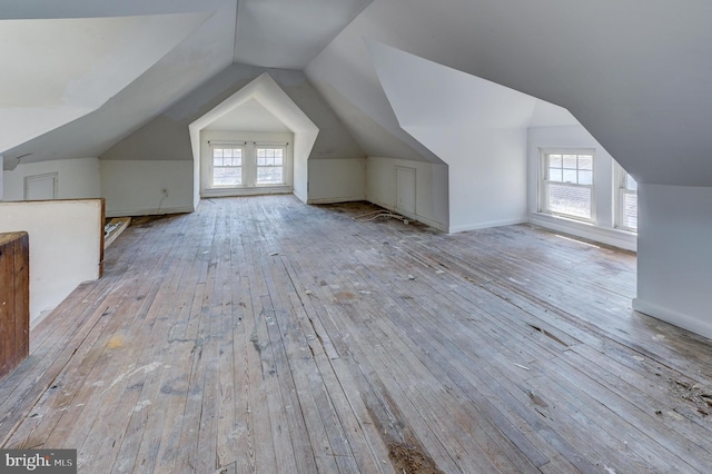 bonus room with wood-type flooring and vaulted ceiling